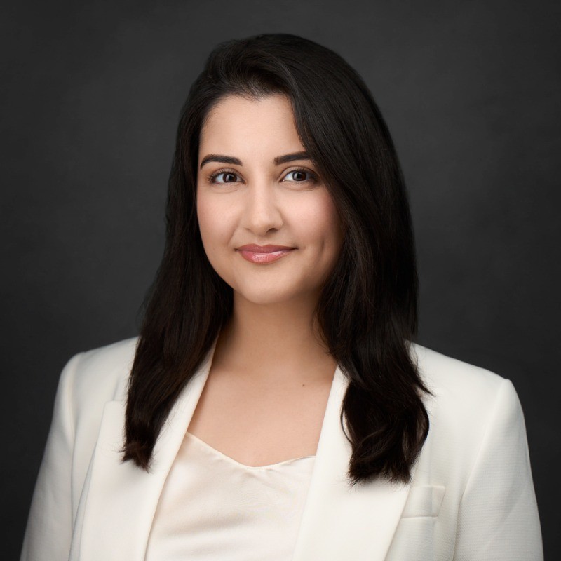 Negin Kazemian, owner of Okanagan Wedding Co., in a studio headshot against a dark grey ground.